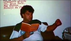 Jovem em oração ajoelhado diante de uma cruz, simbolizando a vocação de Padre Léo ao sacerdócio em 1981.